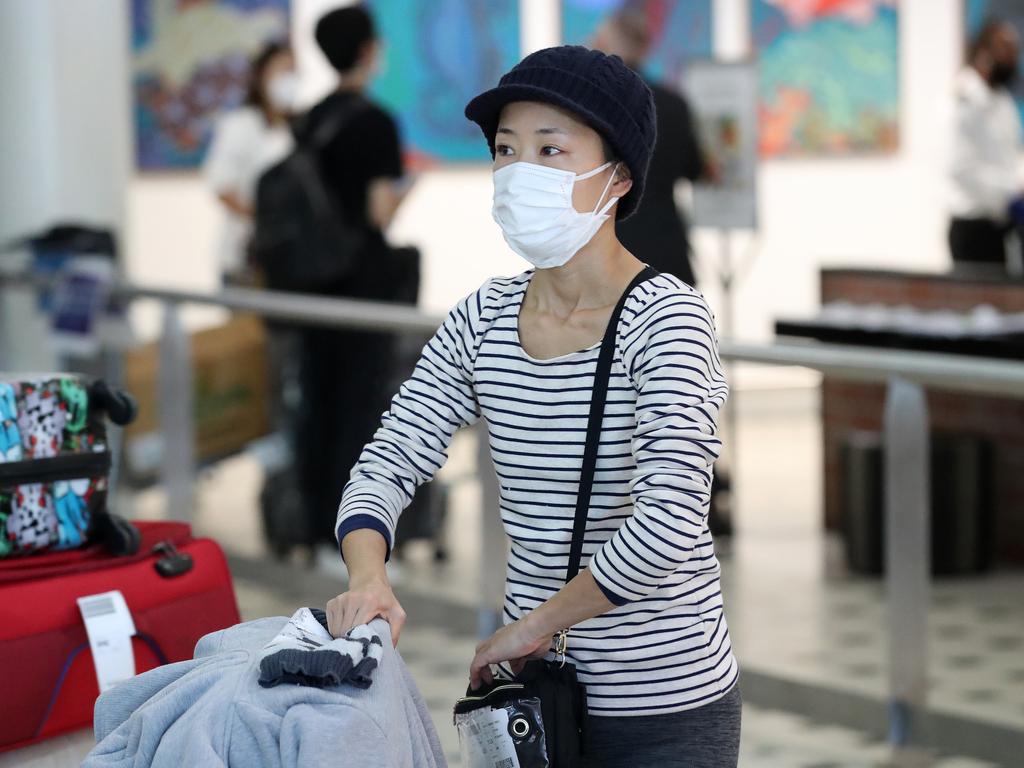 A passenger arrives at Brisbane Airport. All Australian travellers have been told to return as soon as possible. Picture: Liam Kidston