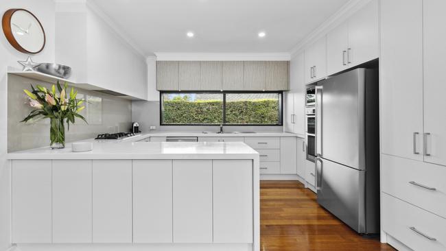 The recently-updated kitchen features stone surfaces and stainless-steel appliances.