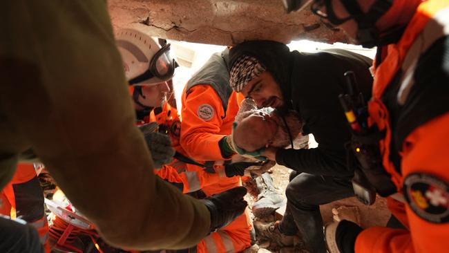 Members of the Swiss rescue team handing over a four-month-old girl called Abir. Picture: AFP