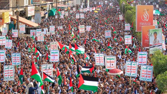 Yemenis chant slogans and wave flags during a march in solidarity with the people of Gaza.