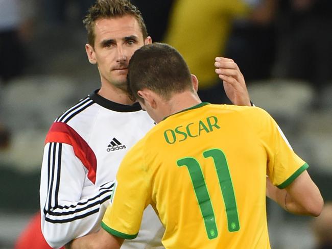 TOPSHOTS Germany's forward Miroslav Klose (L) conforts Brazil's midfielder Oscar after the semi-final football match between Brazil and Germany at The Mineirao Stadium in Belo Horizonte during the 2014 FIFA World Cup on July 8, 2014. AFP PHOTO / PEDRO UGARTE