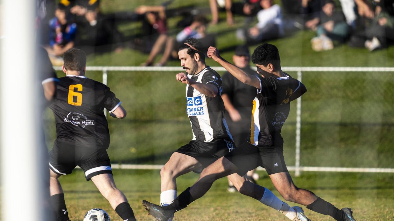 Callum Hart (centre) attacks for Willowburn defended by Jaisal Narsey of West Wanderers in FQPL Men Darling Downs Presidents Cup football at West Wanderers, Sunday, July 24, 2022. Picture: Kevin Farmer