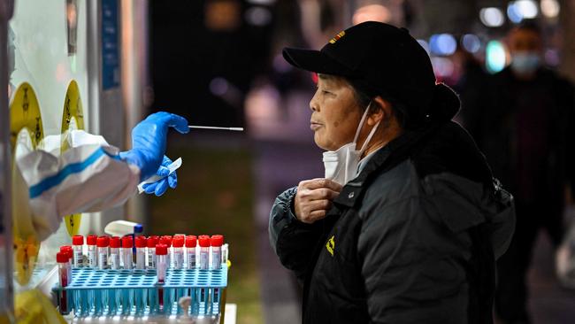 A health worker takes a swab sample from a woman to test for Covid-19 in the Huangpu district in Shanghai on Monday. Picture: AFP