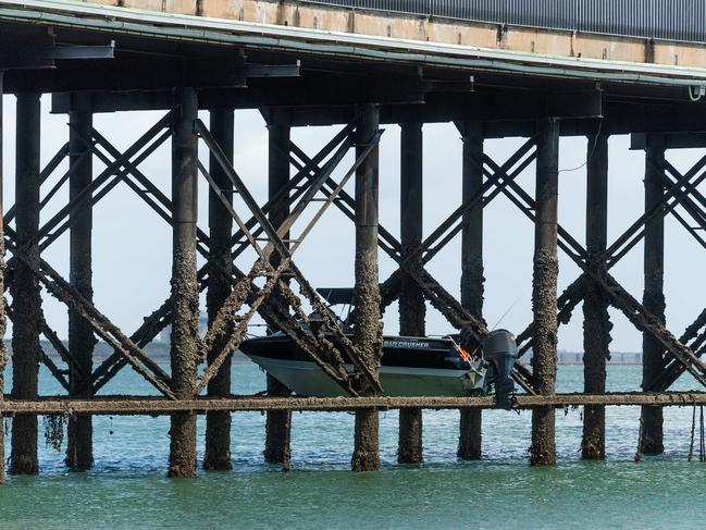 The boat stuck in the pylons of Stokes Hill Wharf as the tide drops today. The owner will have a nervous wait ahead of them to see if there is any damage. Picture: Che Chorley