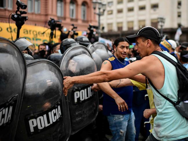 Fans clash with police outside Maradona’s wake.