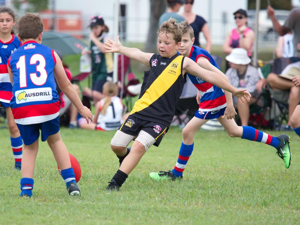 Harry Kerry manages to clear a kick in an U10's match for Bakers creek Tigers. Mackay and District Junior AFL Carnival, August 7, 2022. Picture: Marty Strecker