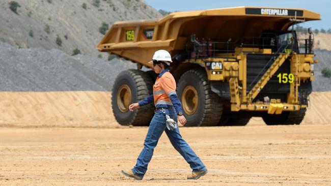 An operator walks past a dump truck at the Caval Ridge coal mine near Moranbah, Central Queensland. Picture: Dan Peled