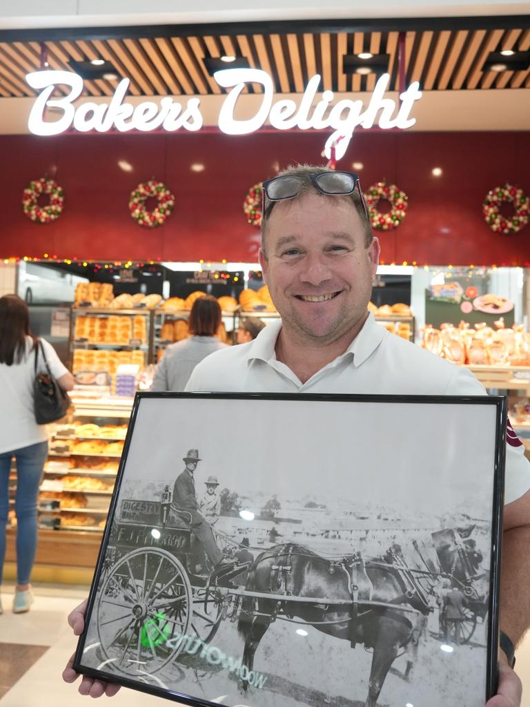 Bakers Delight franchisee Duncan Carter, a fourth-generation baker, has opened his second location in Toowoomba at the Ridge Shopping Centre. He holds a photo of his great-grandfather EJ Bedgood.