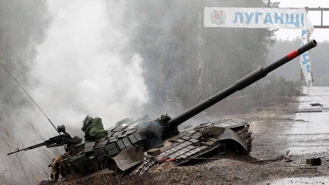 Smoke rises from a Russian tank destroyed by the Ukrainian forces on the side of a road in Lugansk region. Picture: Anatolii Stepanov / AFP