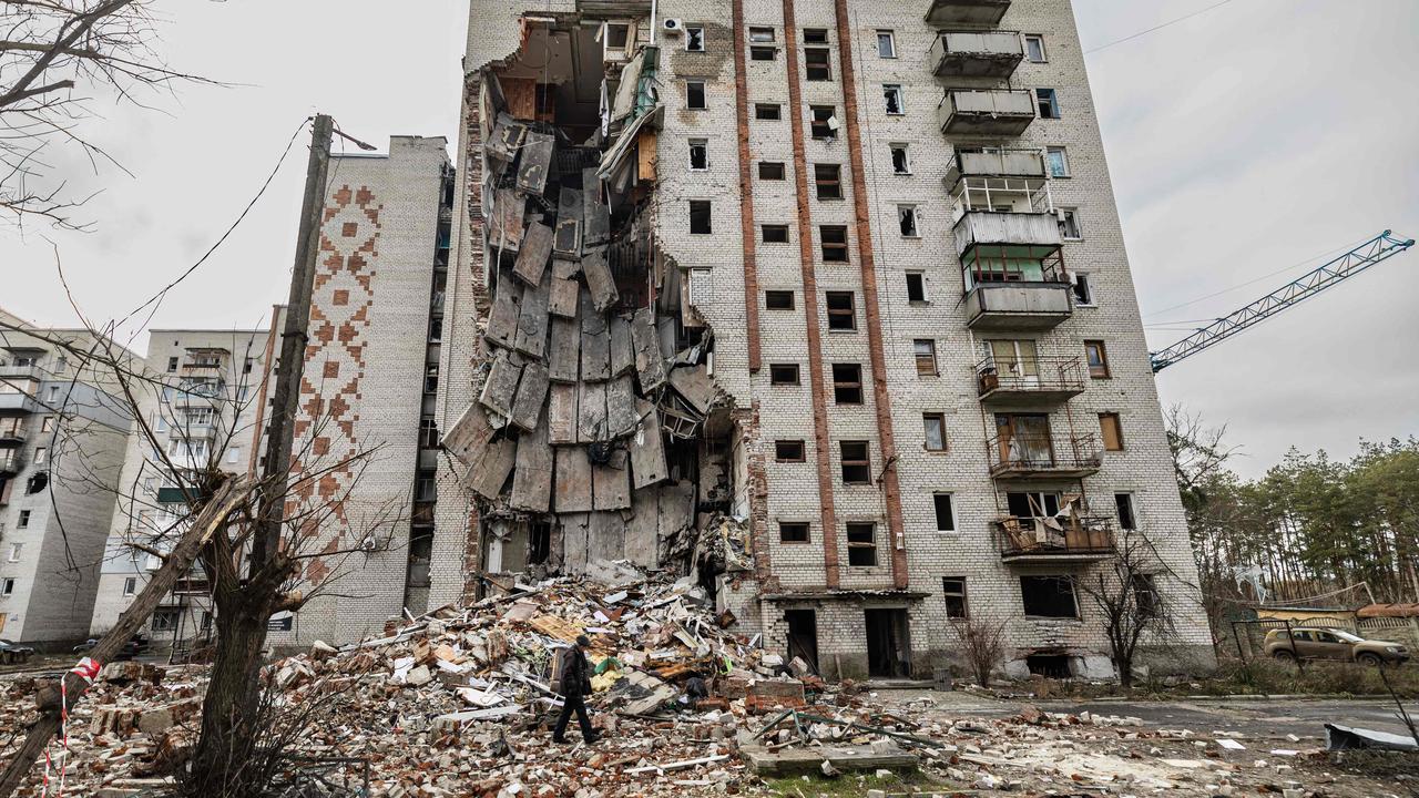 A resident walks next to a destroyed building in the city of Lyman, eastern Ukraine on December 23, 2022. Picture: Sameer Al-Doumy/AFP