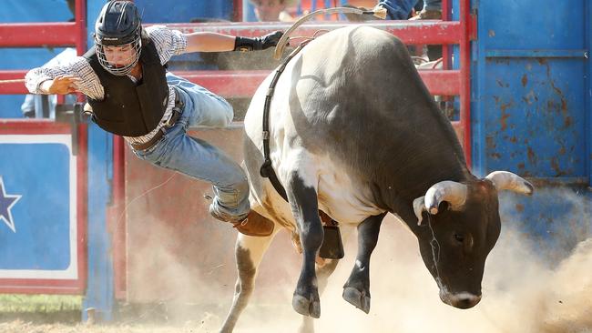 A competitor in the bull ride is sent airborne.