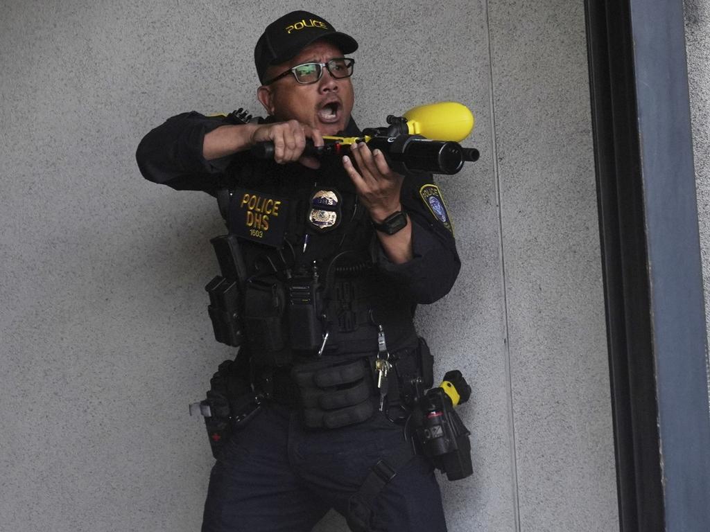A Department of Homeland Security officer reacts after shooting pepper balls during a protest at the U.S. Department of Justice Federal Bureau of Prisons. Picture: AP