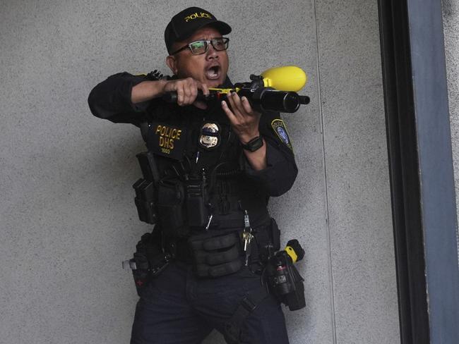 A Department of Homeland Security officer reacts after shooting pepper balls during a protest at the U.S. Department of Justice Federal Bureau of Prisons. Picture: AP