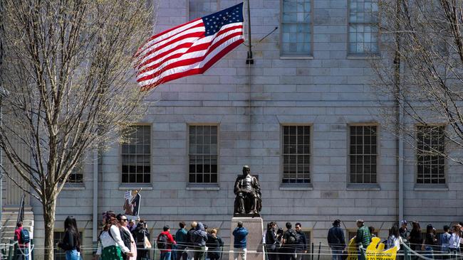 Demonstrators with signs stand around the John Harvard Statue in Harvard Yard. Picture: Joseph Prezioso / AFP
