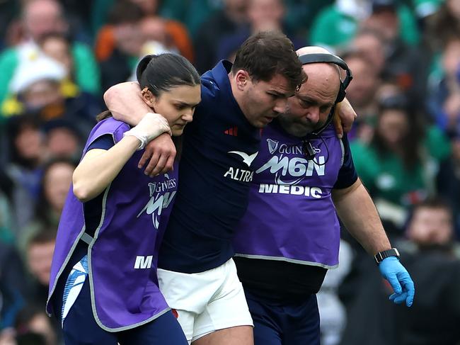 Antoine Dupont, the France captain, is helped off the field after an injury. Photo: David Rogers/Getty Images.