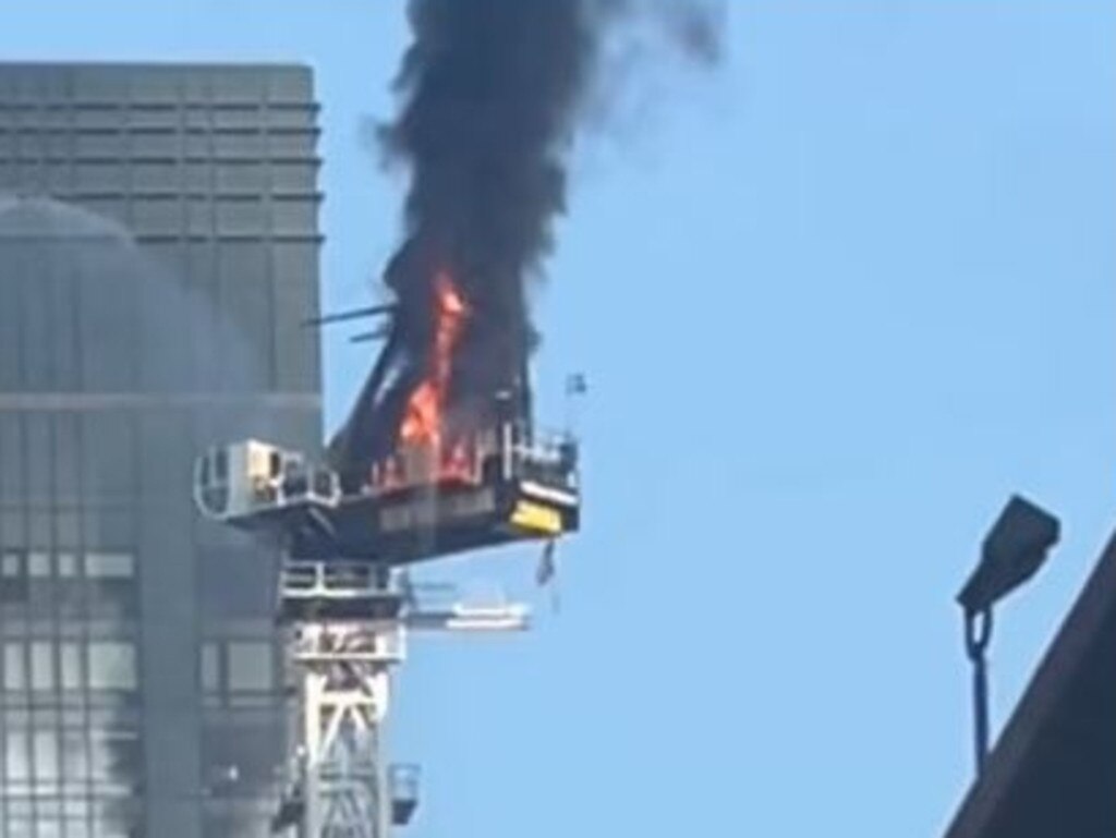 Flames and smoke billow from a crane perched high above New York's midtown Manhattan. Picture: Supplied