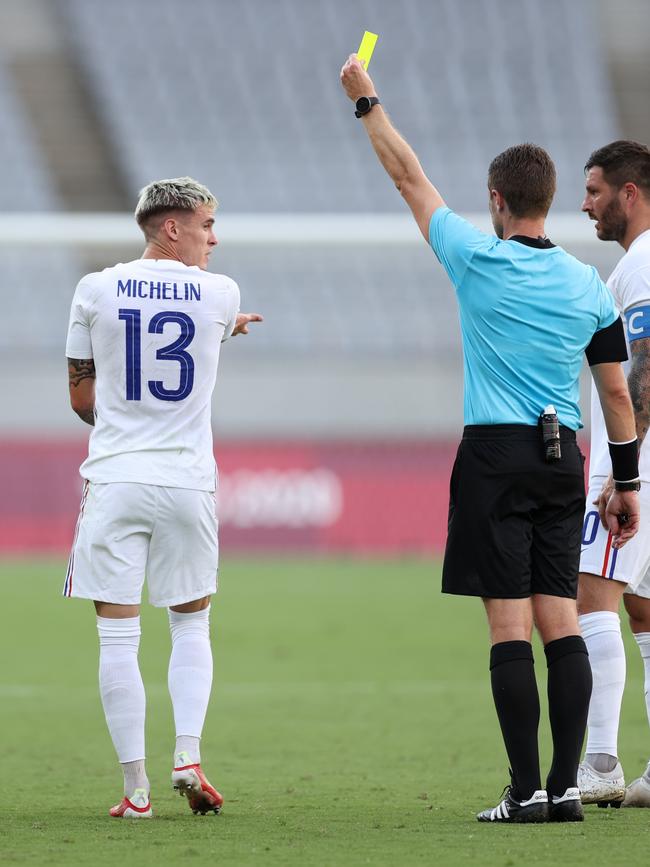 Referee Chris Beath shows a yellow card to France’s Clement Michelin in a Tokyo Olympics football group match. Picture: Dan Mullan/Getty Images