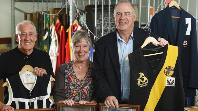 SANFL legends John Cahill and Peter Carey with their old jumpers and exhibition organiser Christine Halbert. Picture: Roger Wyman