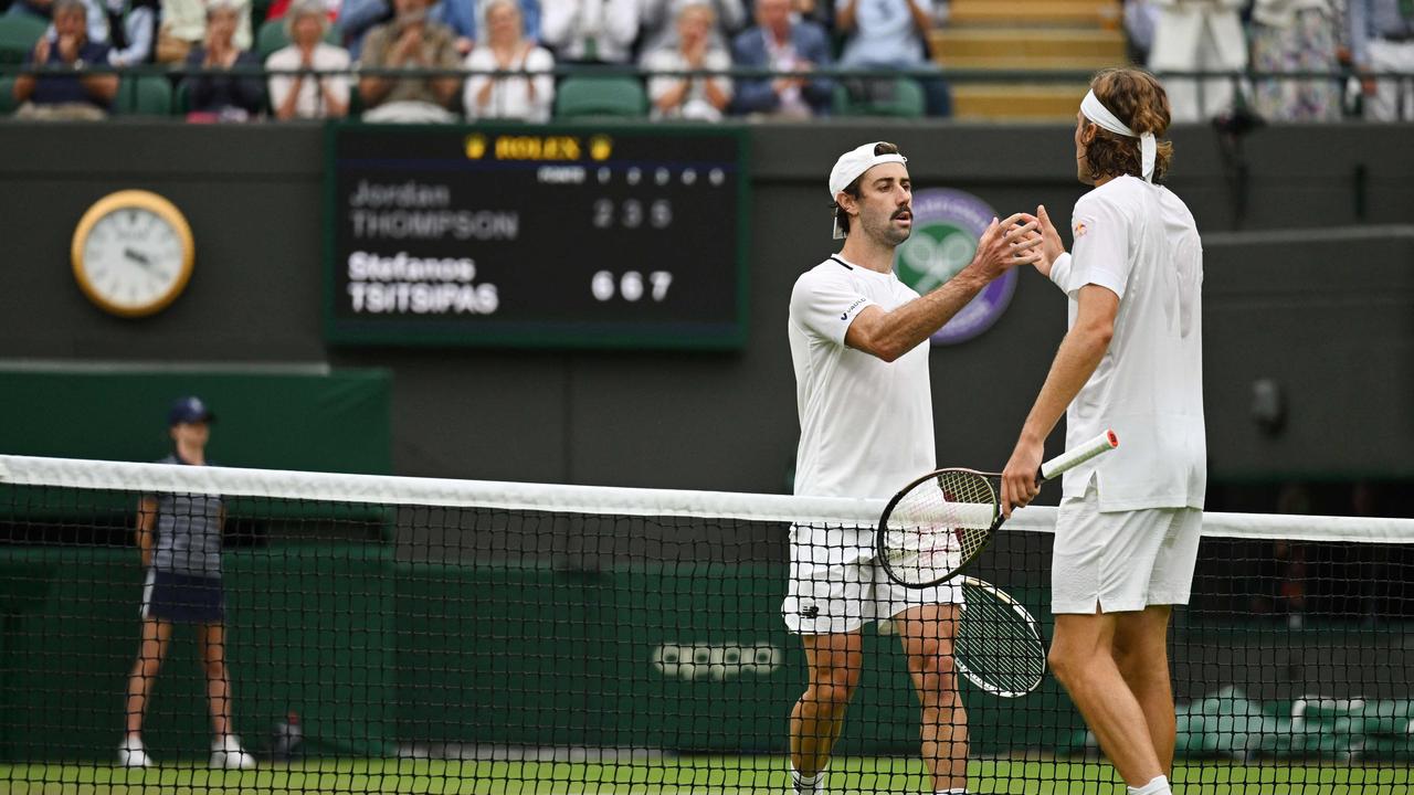 Greece's Stefanos Tsitsipas (R) and Australia's Jordan Thompson shake hands after their men's singles tennis match on the fourth day of the 2022 Wimbledon Championships at The All England Tennis Club in Wimbledon, southwest London, on June 30, 2022. (Photo by SEBASTIEN BOZON / AFP) / RESTRICTED TO EDITORIAL USE