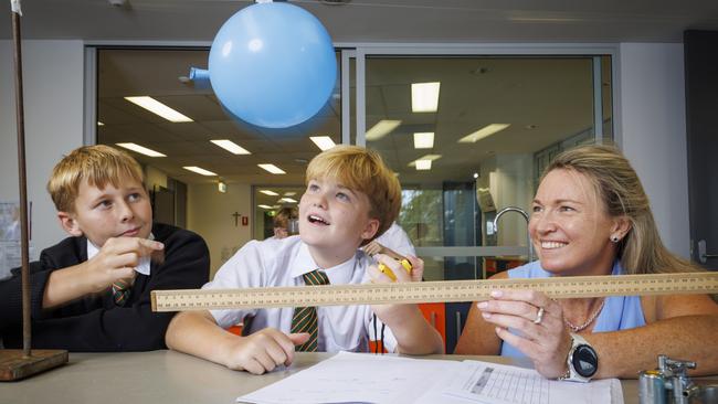 Science teacher Amy Ayres’ love of learning has made her a better teacher. She is with Year 7 students Alfie Gough and Fox Moss at St Augustine's College in Brookvale. Picture: Toby Zerna.