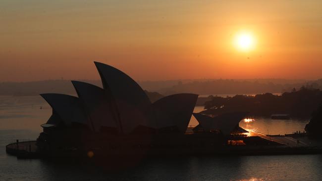 Smoke haze hangs over Sydney Harbour at sunrise. Picture: Bill Hearne.