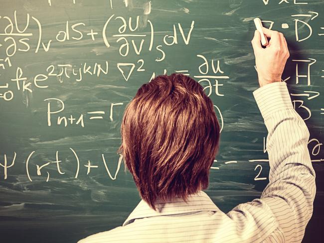 Newton's Equations. Rear view, close-up on young man standing back against green chalkboard. He explains, solves physics tasks, retro style. Processing for retro bleached look, slight vignette added.