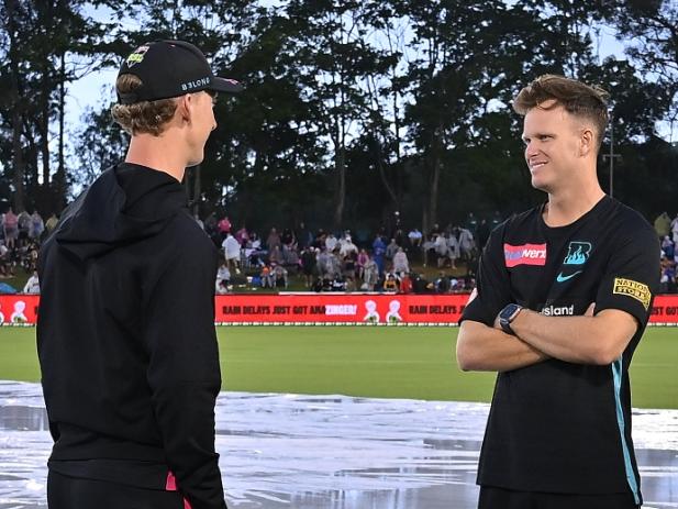 COFFS HARBOUR, AUSTRALIA - JANUARY 03: Jordan Silk of the Sixers and Matt Kuhnemann of the Heat speak as the umpires inspect the field ahead of the BBL match between Sydney Sixers and Brisbane Heat at C.ex Coffs International Stadium, on January 03, 2025, in Coffs Harbour, Australia. (Photo by Albert Perez/Getty Images)