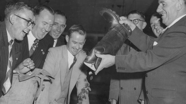 Uncle Bobs Club members count coins collected in a gumboot for the Good Friday Appeal in 1954. Picture: Laurie Richards Studio/Royal Children's Hospital Archives