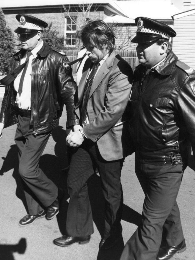 Raymond Bassett is led away by police.