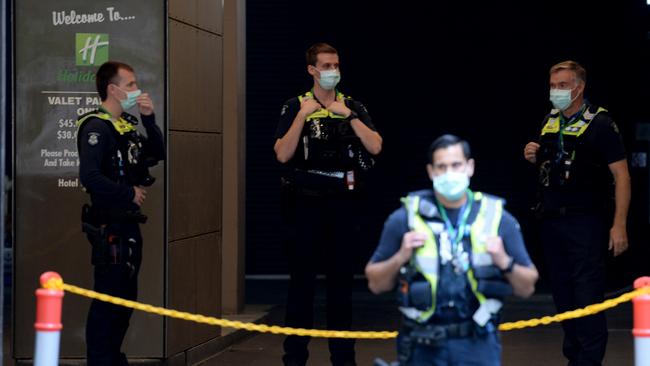 Police stationed outside the Holiday Inn on Flinders Lane as resident prepare to be evacuated. Picture: NCA NewsWire / Andrew Henshaw