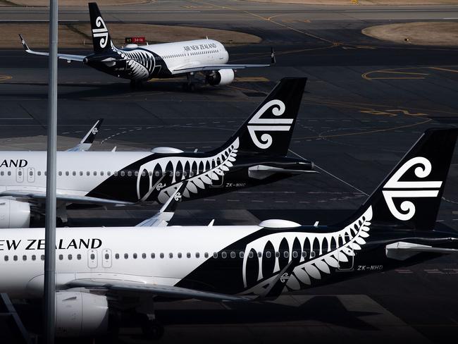 Air New Zealand airplanes wait for passengers outside the international terminal as a plane taxis at Wellington International airport on February 20, 2020. - The New Zealand government announced a bail out package to help the national carrier Air New Zealand survive the Corvid 19 virus down turn. (Photo by Marty MELVILLE / AFP)