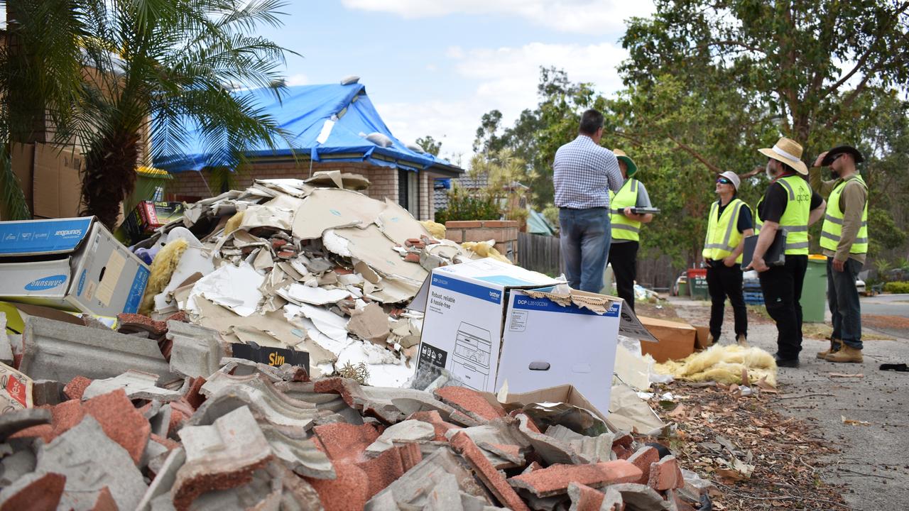 Workers inspect hail-battered homes at Springfield. Photo: Ebony Graveur