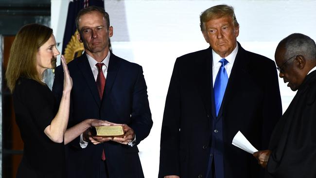 Judge Amy Coney Barrett is sworn in by Justice Clarence Thomas as Donald Trump and Jesse Barrett watch on. Picture: AFP