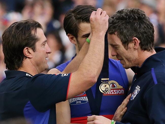 2016 AFL Grand Final match between the Western Bulldogs and the Sydney Swans at the Melbourne Cricket Ground (MCG), Melbourne, Australia on October 1, 2016. Luke Beveridge puts his premiership medal over Bob Murphy's neck on the podium with Easton Wood Picture :Wayne Ludbey