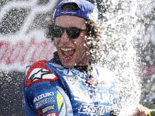 Suzuki Ecstar's Spanish rider Alex Rins sprays champagne on the podium as he celebrates his victory in the Moto GP race of the British Grand Prix at Silverstone circuit in Northamptonshire, central England, on August 25, 2019. - Alex Rins won the British MotoGP in dramatic fashion as the Team Suzuki rider pipped world champion Marc Marquez to the finish line by 0.013 seconds at Silverstone on Sunday. (Photo by Adrian DENNIS / AFP)