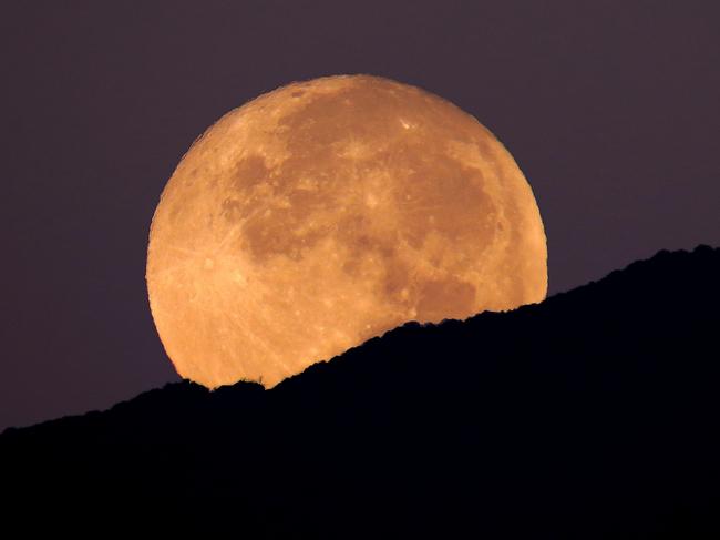 This super moon was shot setting over the Huachuca Mountains in Sierra Vista, Arizona. The super moon occurs when the moon is at its closest point to the earth and appears larger in the sky than normal. It was shot on the morning of the super-blood moon, September 27 2015. The pre-dawn purple hews give an ethereal impression.