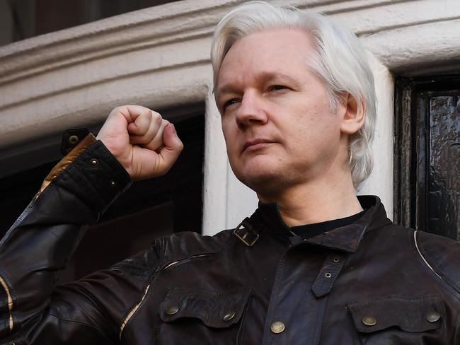 TOPSHOT - Wikileaks founder Julian Assange raises his fist prior to addressing the media on the balcony of the Embassy of Ecuador in London on May 19, 2017. Ecuador urged Britain today to "grant safe passage" out of the country to WikiLeaks founder Julian Assange after Sweden dropped a warrant that drove him to take refuge in Ecuador's London embassy. / AFP PHOTO / Justin TALLIS