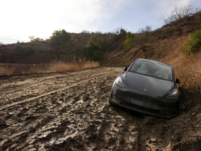 A vehicle is stuck in the mud in an unpaved access road after weekend storms in the Woodland Hills section of Los Angeles. Picture: AP