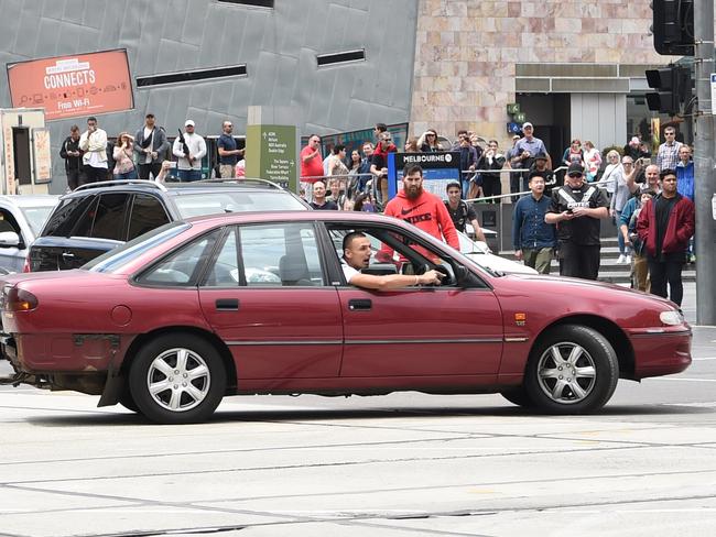 The red car doing burnouts in Flinders St. Picture: Tony Gough