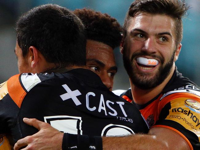 SYDNEY, AUSTRALIA - APRIL 24: Kevin Naiqama of the Tigers celebrates his try with team mates Delouise Hoeter and James Tedesco during the round eight NRL match between the Canterbury Bulldogs and the Wests Tigers at ANZ Stadium on April 24, 2015 in Sydney, Australia. (Photo by Renee McKay/Getty Images)