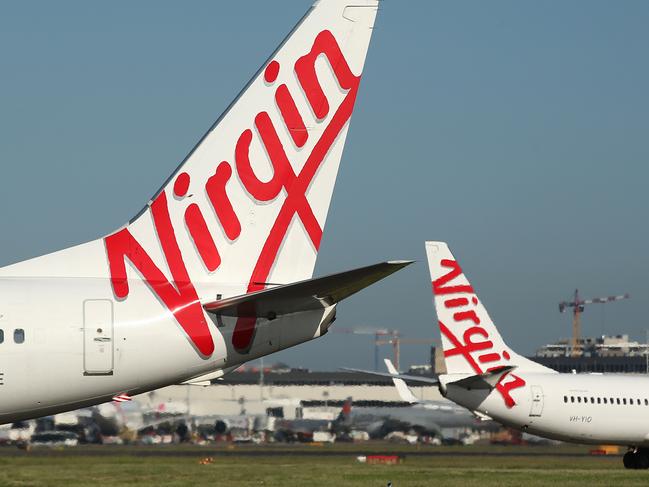 The Virgin Australia Holdings Ltd. logo is displayed on the tails of a Boeing Co. 737-800, left, and a Boeing Co. 737-8FE aircraft preparing to take off at Sydney Airport in Sydney, Australia, on Monday, Feb. 8, 2016. Virgin Australia is scheduled to announce half-year earnings on Feb. 11. Photographer: Brendon Thorne/Bloomberg