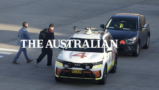 Martin Stephens is helped into a car after arriving at Sydney airport, treatment usually reserved for heads of state. Picture: John Feder