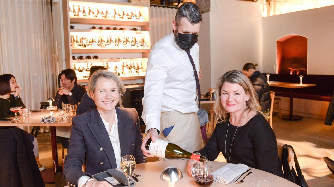 Anna Baillie-Karas and Sarah Killey have wine poured by Adam Waters, head of hospitality at Aurora restaurant. Picture: Brenton Edwards