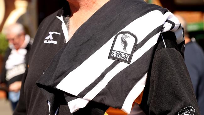 A spectator is seen carrying a Western Suburbs Magpies jersey as he attends the Tommy Raudonikis memorial service. Picture: Mark Kolbe/Getty Images