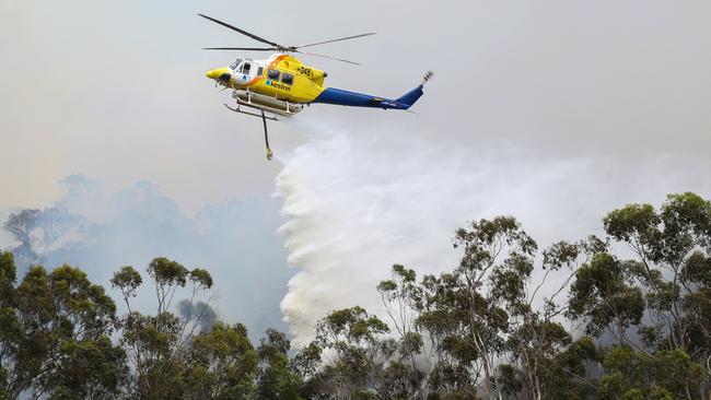 A helicopter drops water over a fire in Plenty Gorge behind Zara Close Bundoora. Picture: Ian Currie