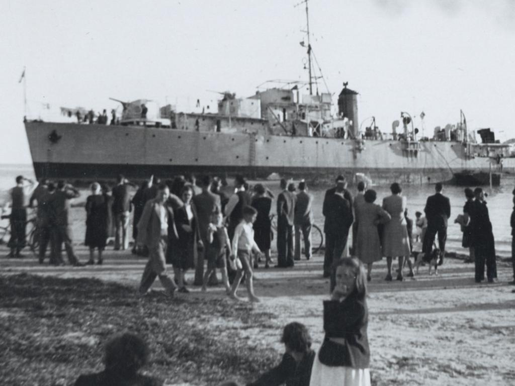 Crowds gather to watch work to refloat the survey frigate H.M.A.S. Barcoo ashore near Glenelg, After several failed attempts Barcoo was refloated on 20 April 1948. Source: State Library of SA 23132