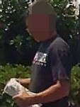 A customer leaving a shop on the Gold Coast alleged to be selling illegal tobacco products with purchase wrapped in a white plastic bag.