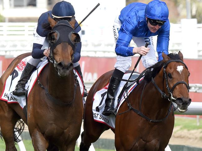 Pat Cosgrave (blue cap) and Best Solution capture the Caulfield Cup from the fast-finishing Ben Melham (navy) and Homesman. Picture: Nicole Garmston