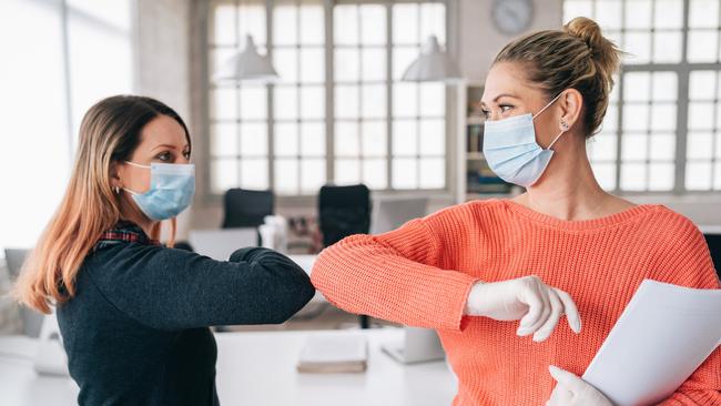 CORONAVIRUS: Colleagues in the office practicing alternative greeting for safety and protection during COVID-19