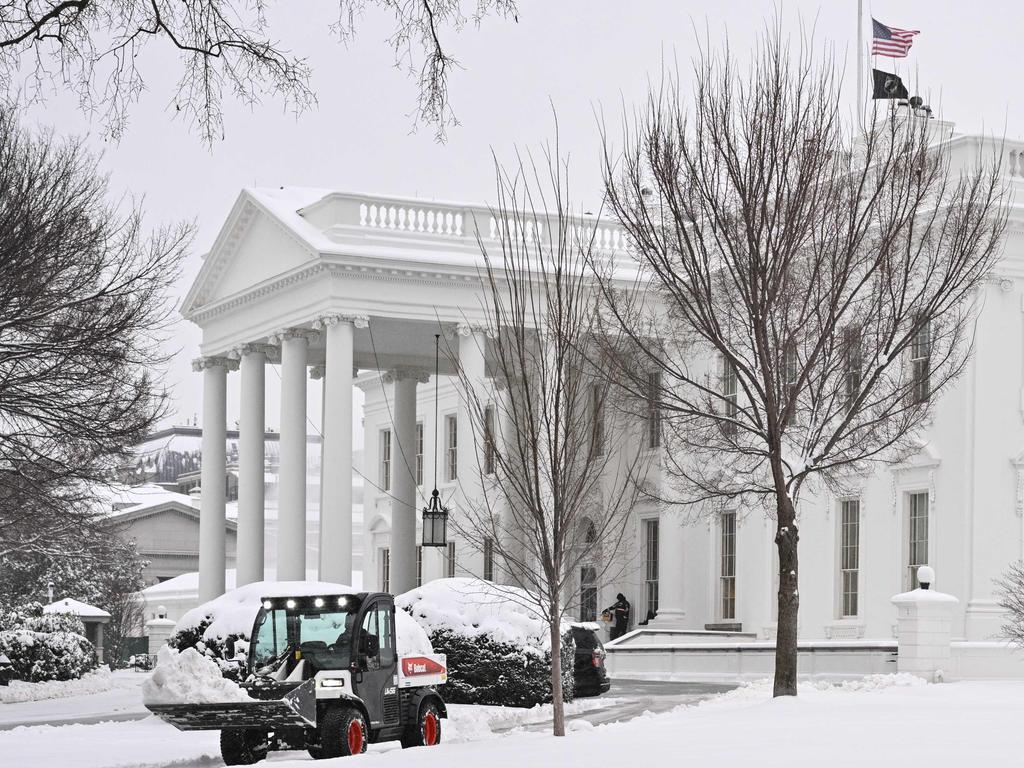 Workers remove snow from a sidewalk at the White House in Washington, DC on January 6, 2025. Picture: AFP